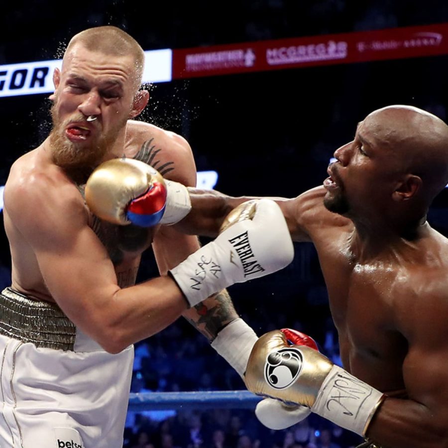 Floyd Mayweather delivers a blow to Conor McGregor in a boxing versus MMA matchup.